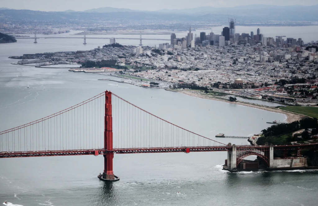 a bridge over water with a city in the background